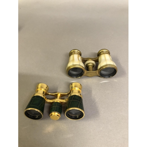 234 - Two pairs of opera glasses in cases, the first in gold metal with panels of cream mother of pearl, c... 