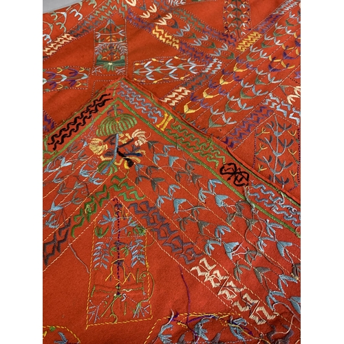 305 - World Textiles: a selection of woven and embroidered textiles, comprising a red felt cover, embroide... 