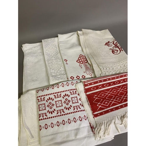 306 - European white on white and red embroidered linen: five towels, one initialled; one skirt panel with... 