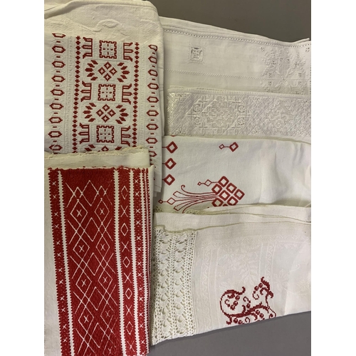 306 - European white on white and red embroidered linen: five towels, one initialled; one skirt panel with... 