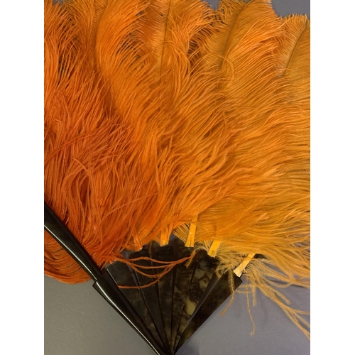 107 - A 1920’s shaded orange ostrich feather fan, light to dark left to right, the monture faux tortoisesh... 