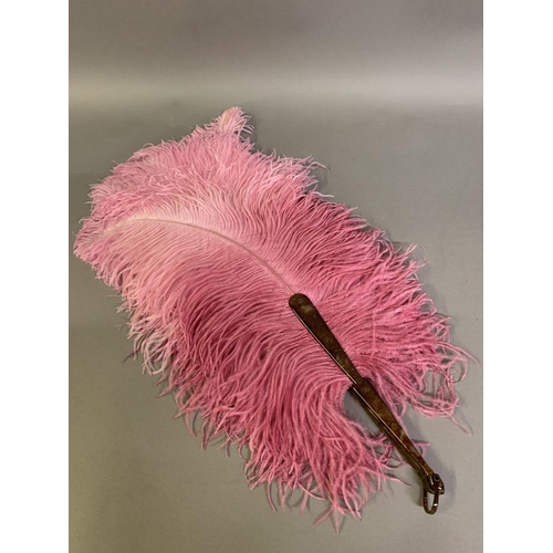 108 - A 1920’s shaded raspberry ostrich feather fan, the upper feathers sugar candy pink, the monture faux... 