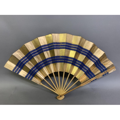 136 - Japanese fans: A dramatic gold and navy blue horizontal striped paper fan with double leaf, design r... 