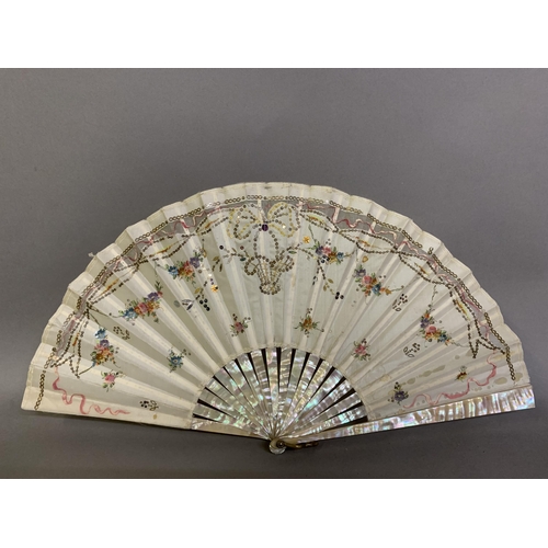 44 - Two mother of pearl fans, the first c 1910, the monture pink, the cream silk leaf backed with cream ... 