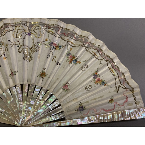 44 - Two mother of pearl fans, the first c 1910, the monture pink, the cream silk leaf backed with cream ... 