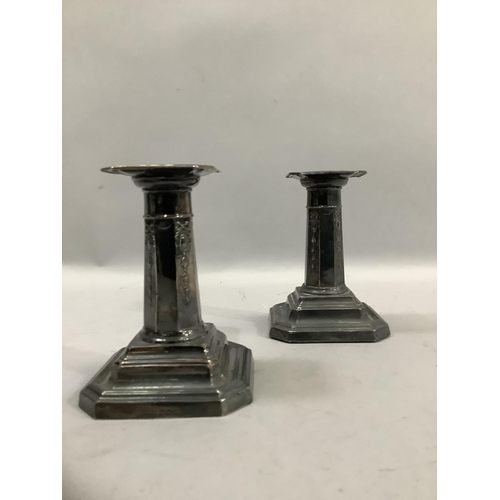 366 - A pair of George V silver candlesticks with octagonal stems over a weighted octagonal foot, hallmark... 