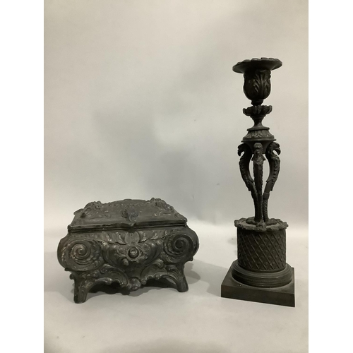 37 - A 19th century bronzed brass candlestick, a leaf cast nozzle and sconce raised on three 
monopied wi... 