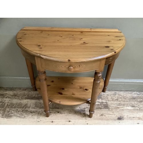 133 - A Ducal pine demi lune table with one drawer and undertier, 89cm wide x 72cm high x 43cm deep