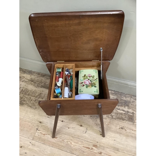 141 - A 1950's teak sewing table with contents, 48cm wide, 47cm high, 38cm deep