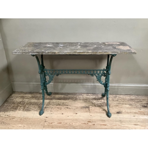 145 - A garden table pine top on ornate wrought iron legs painted in green, the two supports joined by sin... 