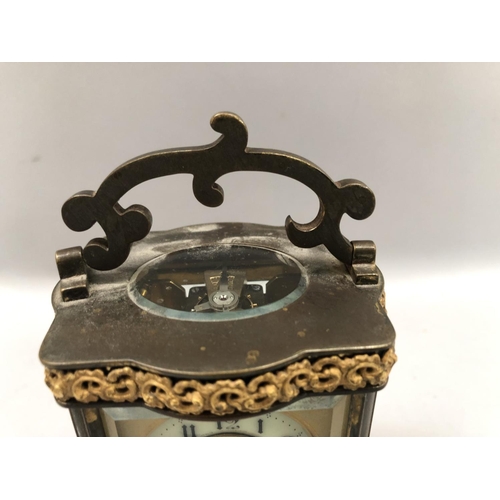 57 - A gilt carriage clock, French movement, having a porcelain dial with Arabic numerals, exposed escape... 