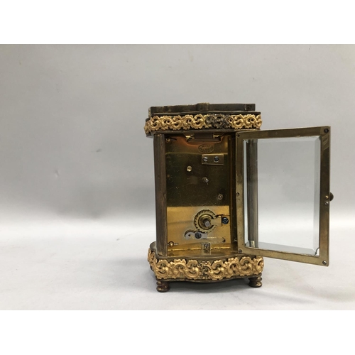 57 - A gilt carriage clock, French movement, having a porcelain dial with Arabic numerals, exposed escape... 