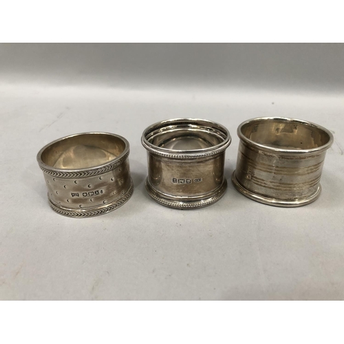 357 - Three early 20th century silver napkin rings together with a silver topped jar, a pill box and cheru... 