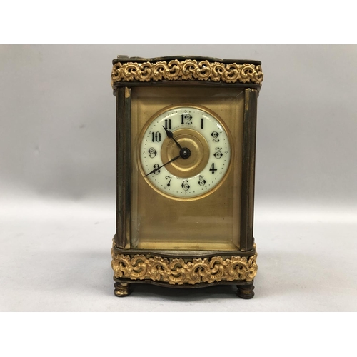 57 - A gilt carriage clock, French movement, having a porcelain dial with Arabic numerals, exposed escape... 