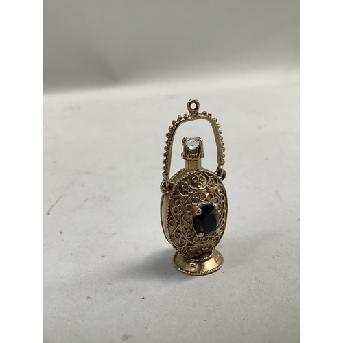 406 - A garnet and spinel set scent bottle charm/pendant in 9ct gold, claw set to each side with an oval f... 