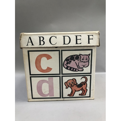 152B - A vintage toy box in white cardboard with alphabet and play toys in orange, pink and black