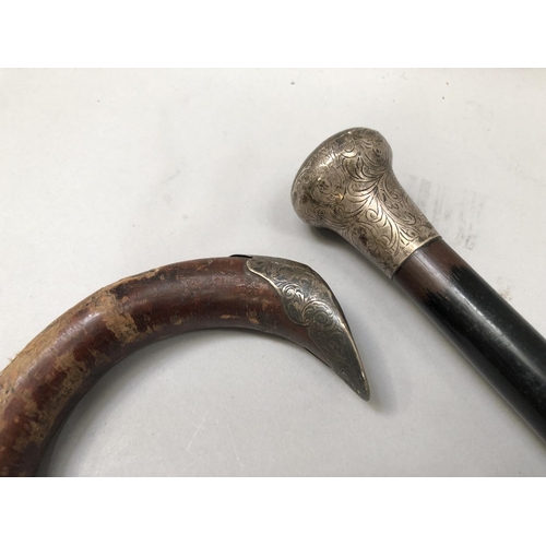 264 - A silver collared crop with antler handle, a silver handled ebonized walking cane and a silver mount... 