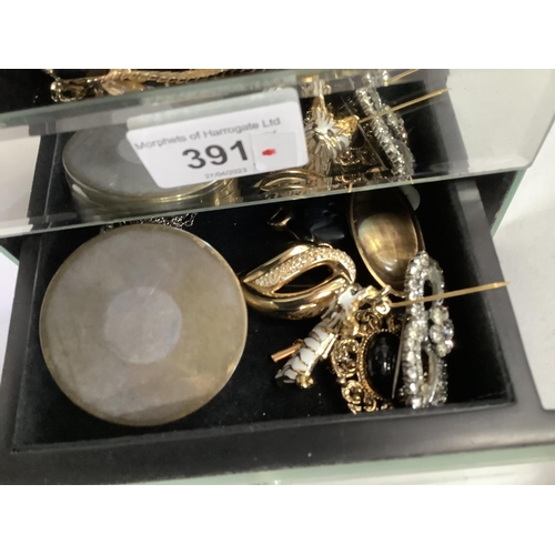 391 - A mirrored jewellery box containing necklaces, brooches etc by various makers, including Christian D... 