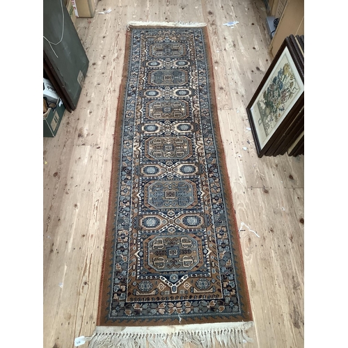 536 - An orange brown and blue Eastern runner with cream tasselling, 240cm x 68cm