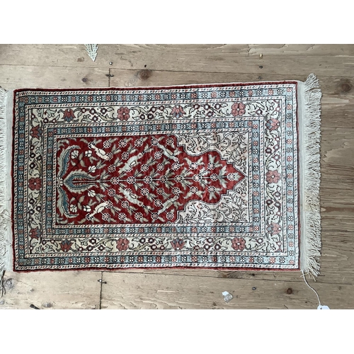 537 - A silk Indian prayer rug with floral borders around central red arch, 67cm x 42cm