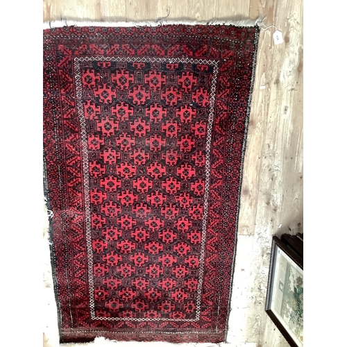 538 - Eastern red and black rug with central geometric pattern, 153cm x 87cm