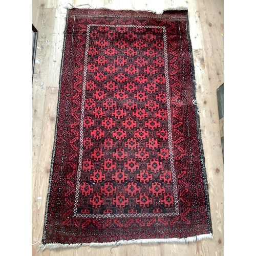 538 - Eastern red and black rug with central geometric pattern, 153cm x 87cm