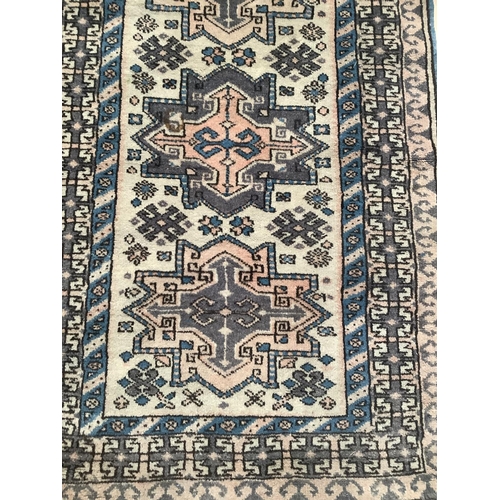 541 - A wool rectangular rug with central cream panel flanked by blue and red border of geometric design, ... 