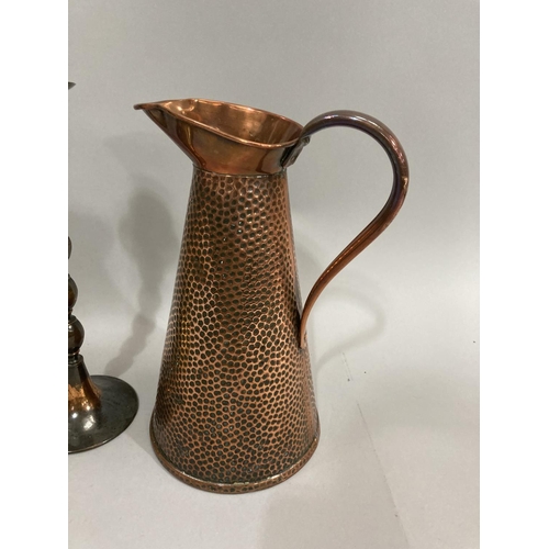 234 - A hammered copper ewer, brass oil lamp with orb shade together with pair of copper bobbin candle sti... 