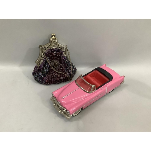 34 - A reproduction friction model pink convertible of American style 27cm long, together with a beaded c... 