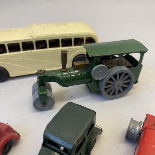 105 - A collection of four Triang Minic clockwork vehicles, including two saloon cars, a tractor (missing ... 