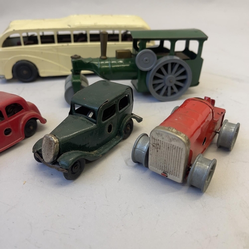 105 - A collection of four Triang Minic clockwork vehicles, including two saloon cars, a tractor (missing ... 