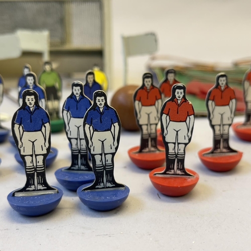 111 - An early edition of Subbuteo, including ten players for each side, two goal keepers and two wooden f... 