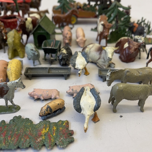 112 - A collection of early Britains lead and cast farmyard animals and accessories, including cows, horse... 