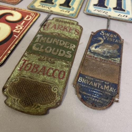 67 - A collection of nine painted tin grocery price tags and advertising signs, including two match strik... 