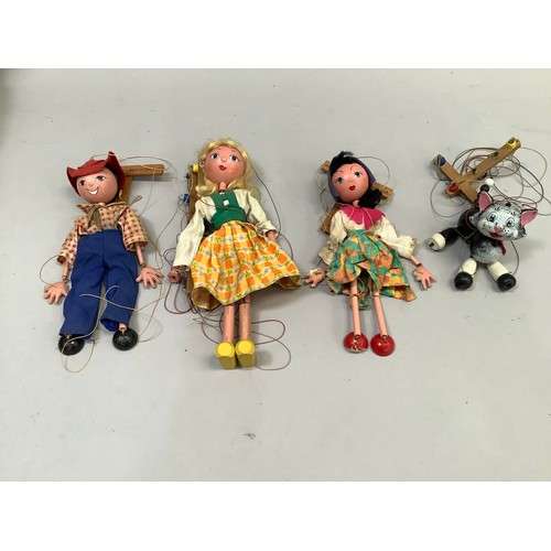 86 - Four Vintage Pelham puppets, including a black and white cat, Tyrolean girl in yellow and orange che... 