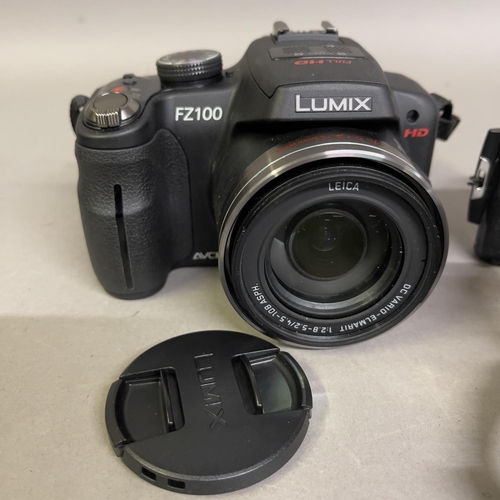 32 - A Panasonic LUMIX FZ100 digital camera with carry case and two batteries, a Sony DSC-T500 digital ca... 