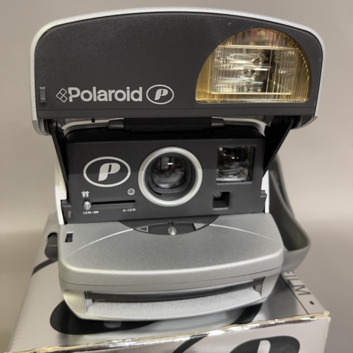 33 - A Polaroid 600 instant camera, boxed, along with an Agfa Mini 110 format camera. Untested.