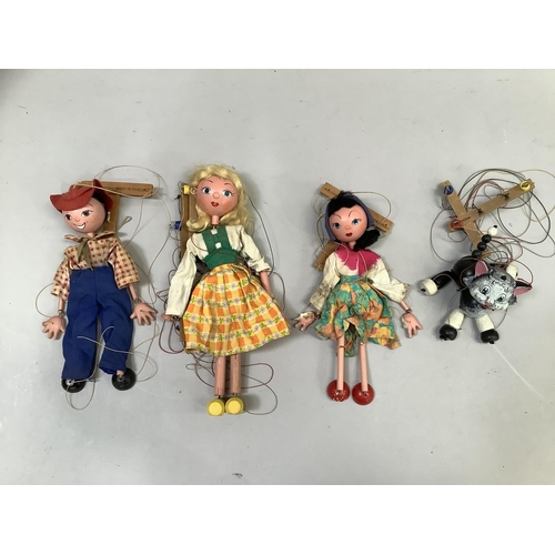 86 - Four Vintage Pelham puppets, including a black and white cat, Tyrolean girl in yellow and orange che... 