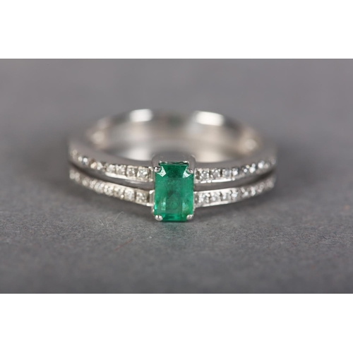 185 - AN EMERALD AND DIAMOND RING IN 18CT WHITE GOLD, claw set to the centre with a step cut emerald flank... 