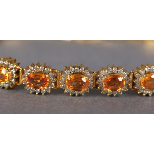 186 - A YELLOW SAPPHIRE AND DIAMOND BRACELET, the oval faceted sapphires claw set, raised against a surrou... 