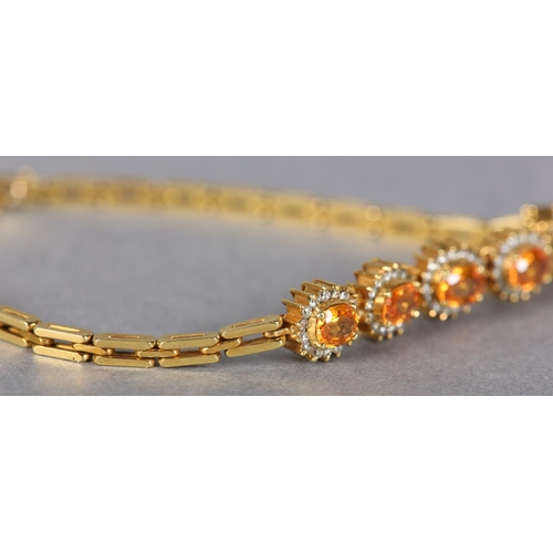 186 - A YELLOW SAPPHIRE AND DIAMOND BRACELET, the oval faceted sapphires claw set, raised against a surrou... 