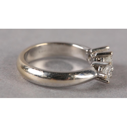 173 - A THREE STONE DIAMOND RING, the graduated brilliant cut stones each in a four claw setting in a spac... 