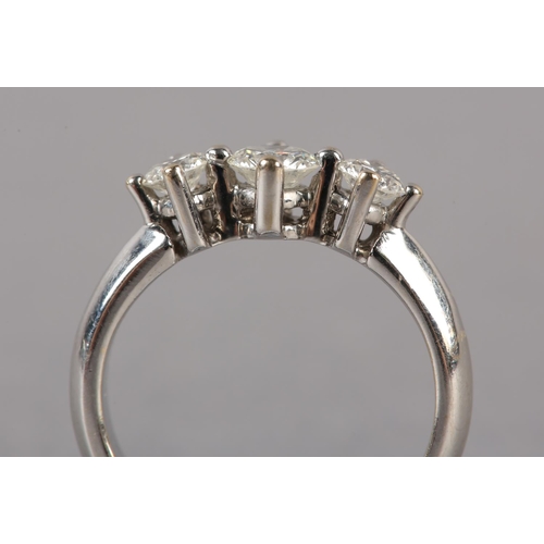 173 - A THREE STONE DIAMOND RING, the graduated brilliant cut stones each in a four claw setting in a spac... 