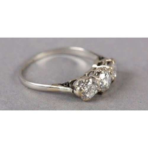 176 - A THREE STONE DIAMOND RING in platinum, c1960, the graduated brilliant cut stones claw set in line, ... 