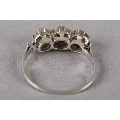 176 - A THREE STONE DIAMOND RING in platinum, c1960, the graduated brilliant cut stones claw set in line, ... 