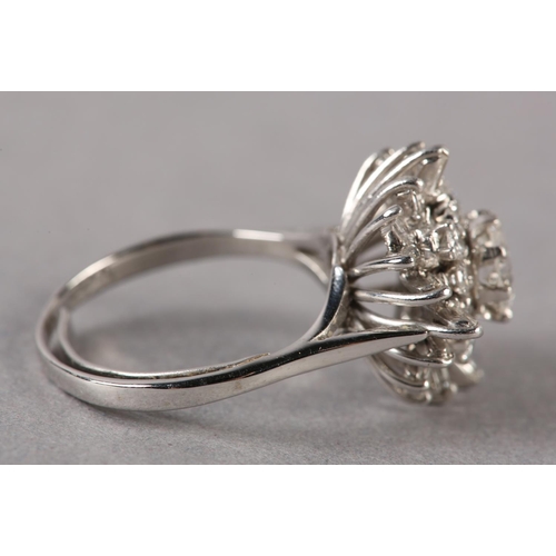 183 - A DIAMOND CLUSTER RING, the principal brilliant cut stone claw set and raised against undulating tie... 