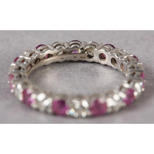 177 - A RUBY AND DIAMOND ETERNITY RING BY TIFFANY AND CO in platinum, the circular faceted rubies and bril... 