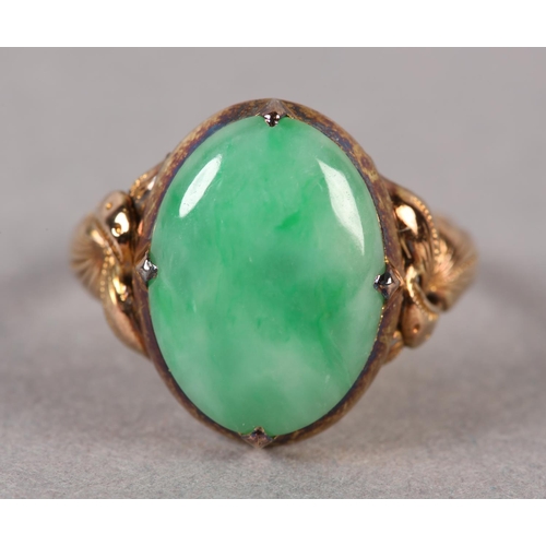 178 - A JADE DRESS RING C1950 in 14ct gold the oval cabochon stone claw set and flanked by applied foliate... 