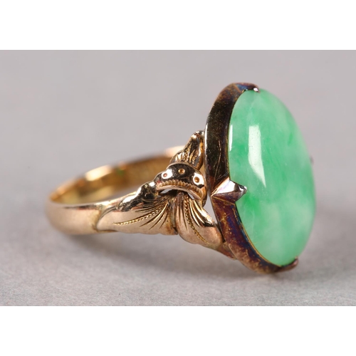 178 - A JADE DRESS RING C1950 in 14ct gold the oval cabochon stone claw set and flanked by applied foliate... 