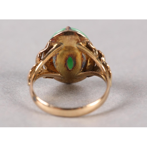 178 - A JADE DRESS RING C1950 in 14ct gold the oval cabochon stone claw set and flanked by applied foliate... 